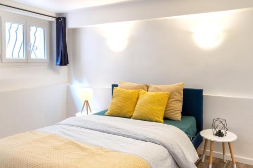 een slaapkamer met een bed met gele kussens bij À 200M de la Gare Matabiau - Appartement tout équipé en Hypercentre - in Toulouse
