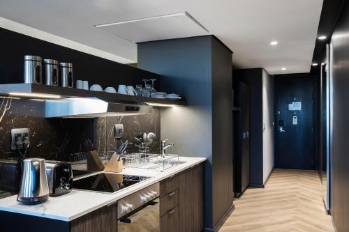 a kitchen with a counter and a blue wall at The Capital 15 on Orange Hotel & Spa in Cape Town