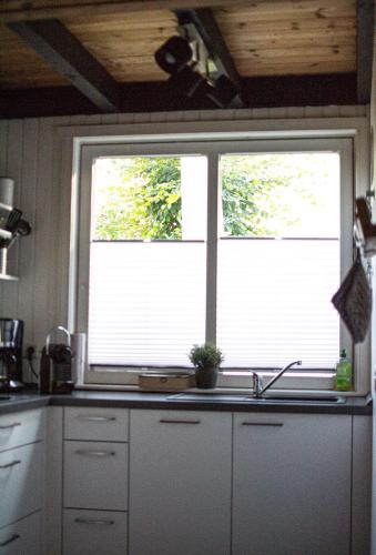 a kitchen with a sink and two windows in it at Hideaway Extertal in Extertal