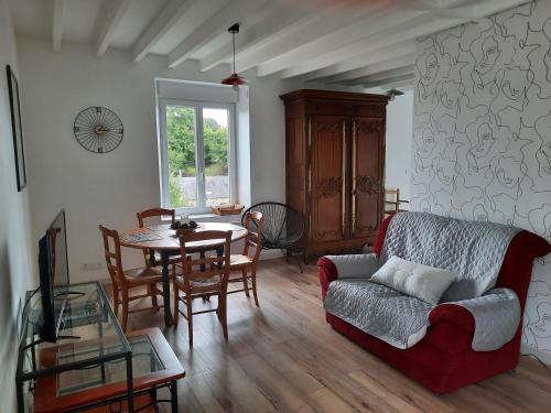 uma sala de estar com um sofá e uma mesa em GITE CHEZ BERTHE em Pontfarcy