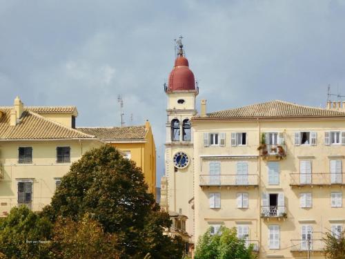 a building with a tower with a clock on it at Villa Maria 1 in Paleokastritsa