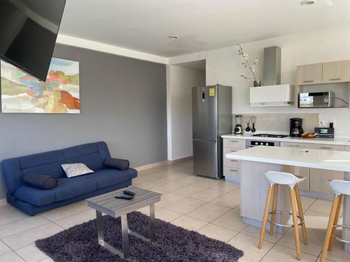a living room with a blue couch and a kitchen at Boutique Apartment Downtown 707 two bedrooms in Mexico City