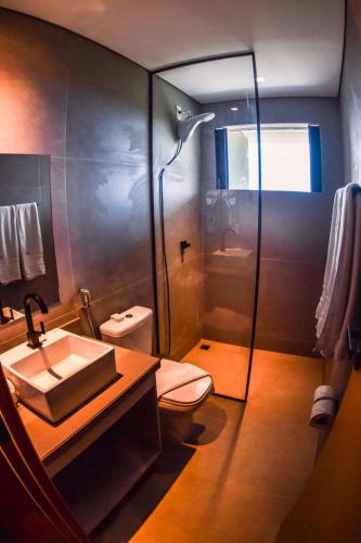 a bathroom with a shower and a sink and a toilet at Miragem Noronha in Fernando de Noronha