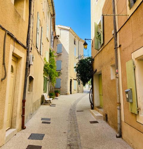 an empty street in an alley between two buildings at Les Arcades Le Lion D'or in Buis-les-Baronnies