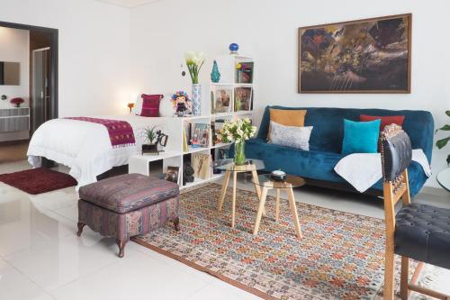 a living room with a blue couch and a bed at Loft Sinaloa By The Local Way in Mexico City