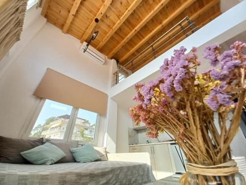 a living room with a couch and a vase of purple flowers at KTIMA MORAITI - Seaside Houses in Katerini