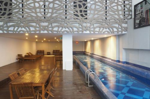 a restaurant with wooden tables and a pool at Loft Sinaloa By The Local Way in Mexico City