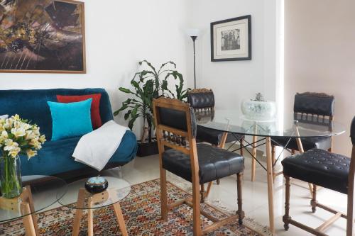 a living room with a blue couch and a glass table at Loft Sinaloa By The Local Way in Mexico City