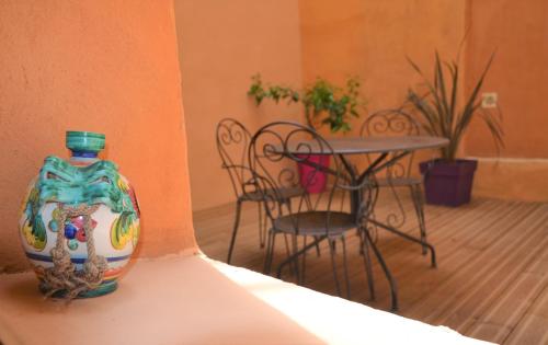 a vase sitting on a shelf next to a table at Les Arcades Le Lion D'or in Buis-les-Baronnies