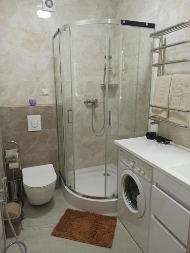 uma casa de banho com um chuveiro e uma máquina de lavar roupa em Marko de Luxe em Ivano-Frankivsk