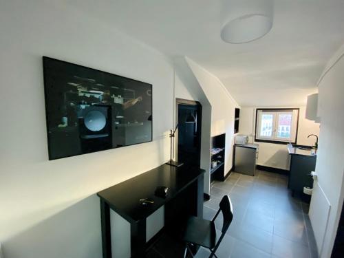 un salon avec une table et une télévision sur un mur dans l'établissement Suite Apollon - Centre-ville, à Saint-Étienne