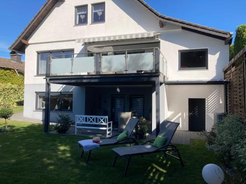 a house with two chairs and a balcony at Atempause mit Wellnessflair, Infrarotsauna in Nideggen