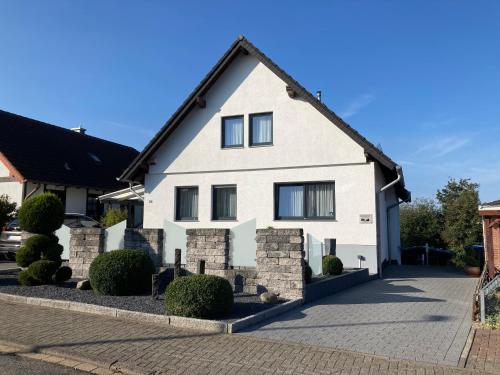 a white house with a black roof at Atempause mit Wellnessflair, Infrarotsauna in Nideggen