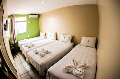 Cidade Verde Flat Hotel في جواو بيسوا: سريرين في غرفة الانحناء عليهم
