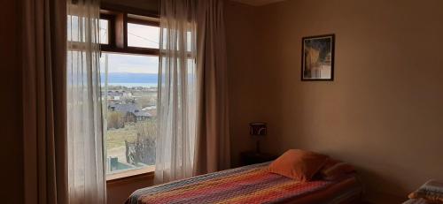 1 dormitorio con cama y ventana con vistas en SHOTEL Calafate en El Calafate