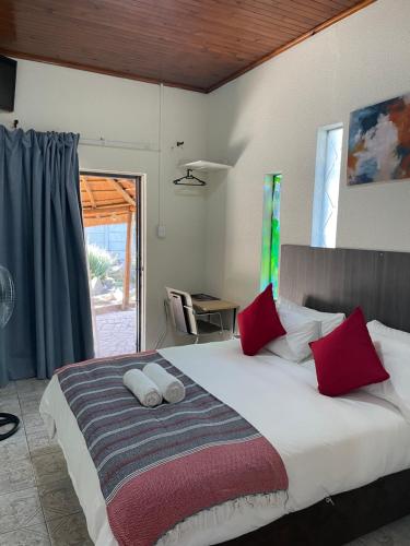 ケンプトンパークにあるHost Hub Guest Houseのベッドルーム1室(大型ベッド1台、赤い枕付)