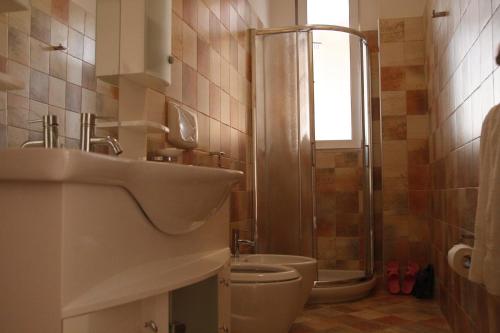a bathroom with a sink and a toilet and a shower at Hotel Nimfa in Vlorë