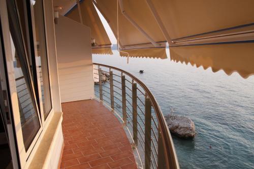 a balcony of a house looking out at the water at Hotel Nimfa in Vlorë