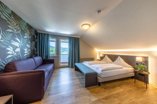 een hotelkamer met een bed en een bank bij Landgasthof Kranz in Ohlsbach