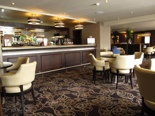 a bar in a hotel with chairs and a counter at Best Western Heath Court Hotel in Newmarket