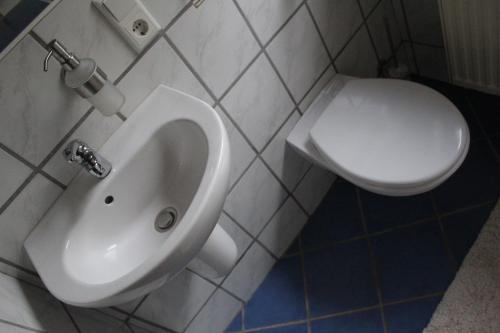 een badkamer met een wit urinoir en een toilet bij Ferienhaus Im Winkel in Krummhörn