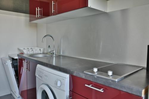 uma cozinha com um lavatório e uma máquina de lavar roupa em Le Belvédère - T2 en front de mer em Argelès-sur-Mer