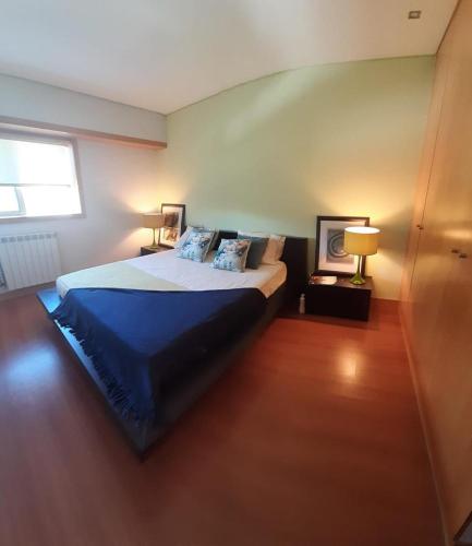 a bedroom with a bed with blue sheets and a window at Terraços de Seixas in Caminha