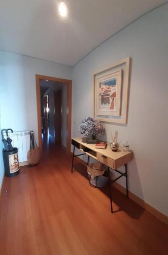 a living room with a table and a wooden floor at Terraços de Seixas in Caminha