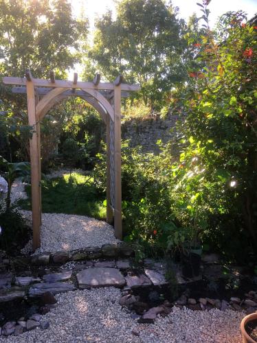 a wooden archway in the middle of a garden at HORTUS HOUSE - Regency style apartment with attached parking in Brixham