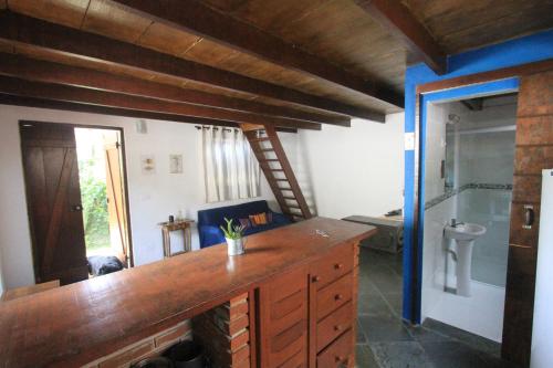 a kitchen with a wooden counter top in a room at Chalés boiçucanga in Boicucanga