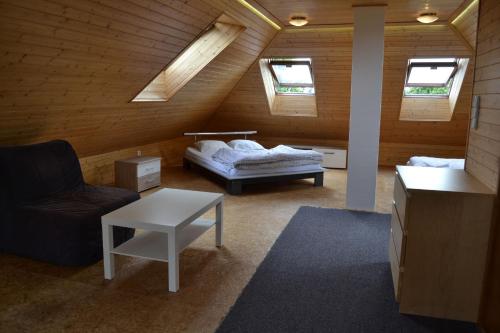 een kamer met een bed en een bank op zolder bij Horský hotel Anděl in Andělská Hora