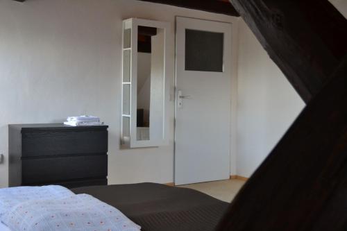 a bedroom with a door and a bed and a dresser at Horský hotel Anděl in Andělská Hora