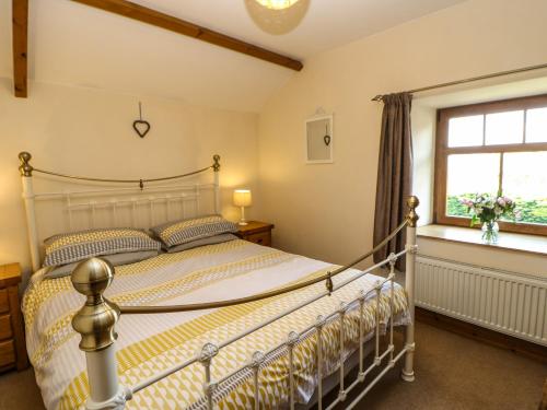 a bedroom with a bed and a window at The Barn Cottage in Slaley