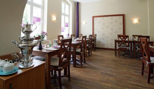 uma sala de jantar com mesas e cadeiras de madeira em Gut Hotel Stadt Beelitz em Beelitz