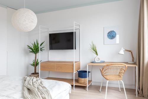 a bedroom with a desk and a tv and a chair at Zatoka Relaksu Mechelinki in Mechelinki