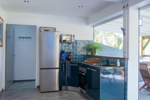 a kitchen with a refrigerator and a sink at BLUE DREAM SPA in Les Trois-Îlets