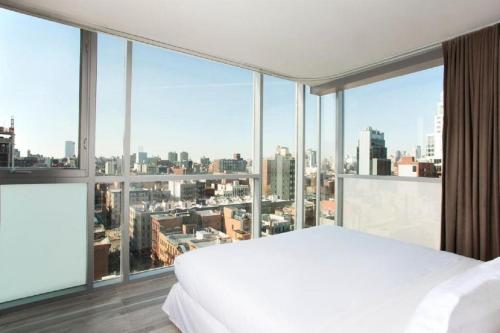sypialnia z białym łóżkiem i dużym oknem w obiekcie Hotel on Rivington w Nowym Jorku