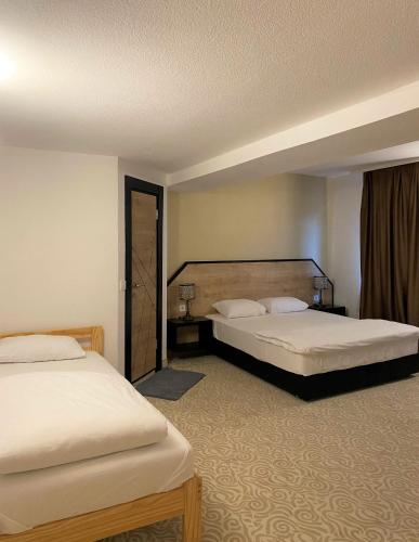 a hotel room with two beds and a window at Hotel Fluss Oase - Feldschlößchen in Weißenfels