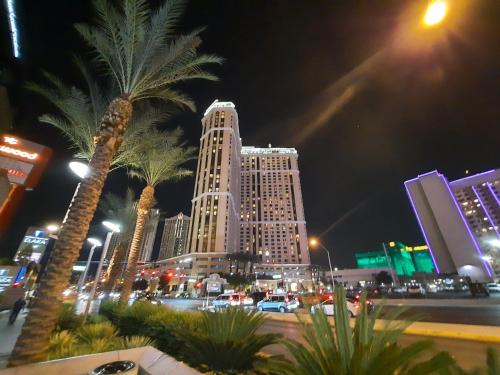 a city at night with tall buildings and palm trees at Suites at Marriott's Grand Chateau Las Vegas-No Resort Fee in Las Vegas