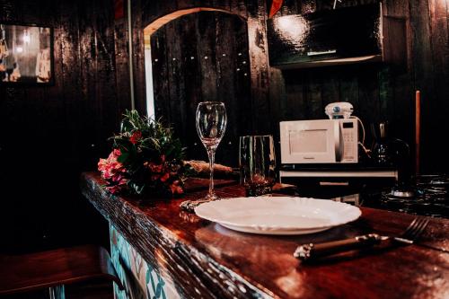 un tavolo con un piatto e un bicchiere di vino di Pipa Merlot a Petrópolis