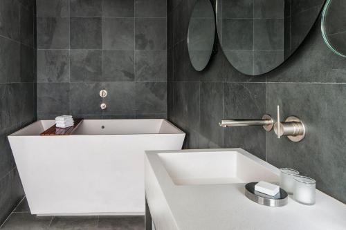 a bathroom with a white sink and a mirror at Hotel on Rivington in New York