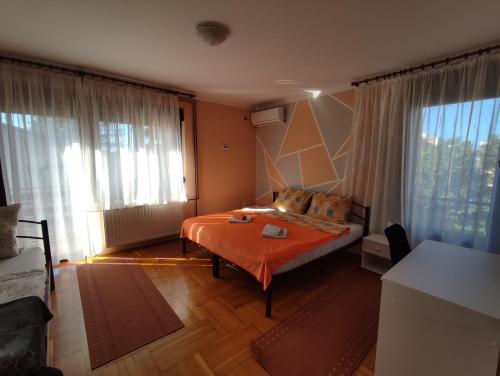 a bedroom with a bed and a large window at Apartments & Rooms 4 Rijeke in Karlovac