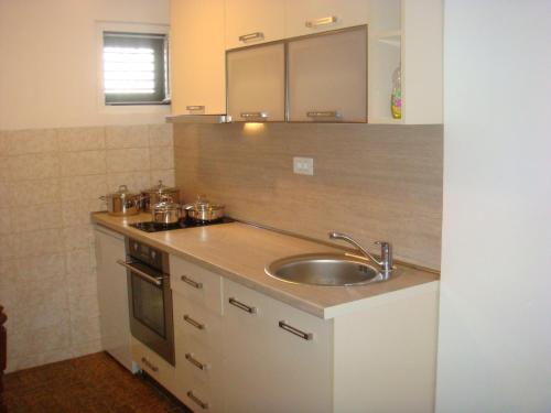 a kitchen with a sink and a counter top at Apartmani Dragović in Sveti Stefan