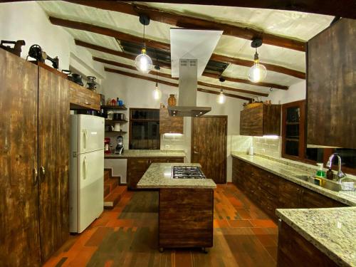 a large kitchen with wooden cabinets and a white refrigerator at Finca Agrreste in Nemocón