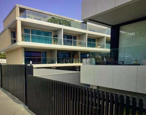 a large building with a fence in front of it at Cozy canide beach apartment in Canidelo