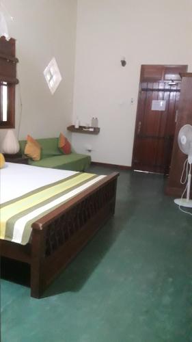 a bedroom with a bed and a green floor at Majestic Beach Retreat in Kalpitiya