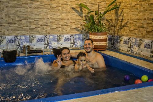 um homem e uma mulher e um bebé numa banheira de hidromassagem em Hotel Trujillo Plaza em Trujillo
