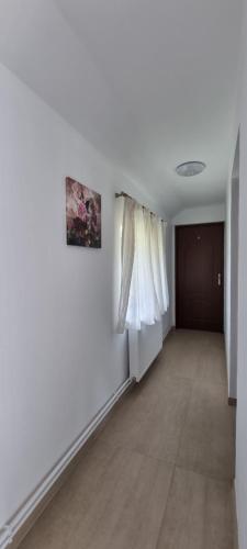 an empty hallway with white walls and a door at Cusali Pensiune in Topolovăţu Mare