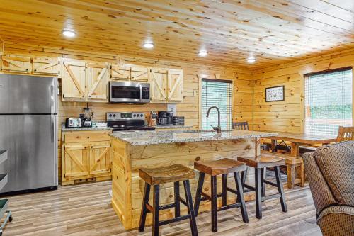 a kitchen with a large island in a log cabin at Knotty Escape in Gatlinburg