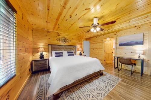 een slaapkamer met een bed en een plafondventilator bij Knotty Escape in Gatlinburg